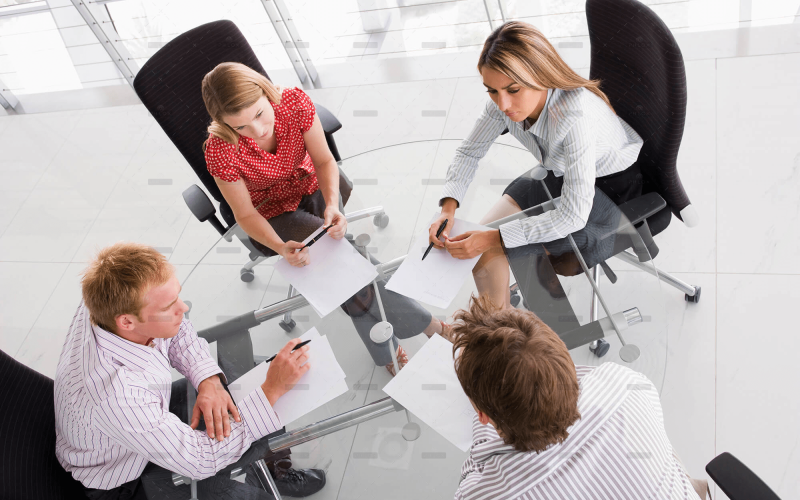 demo-attachment-458-four-businesspeople-in-a-boardroom-with-paperwork-PC4V8H4